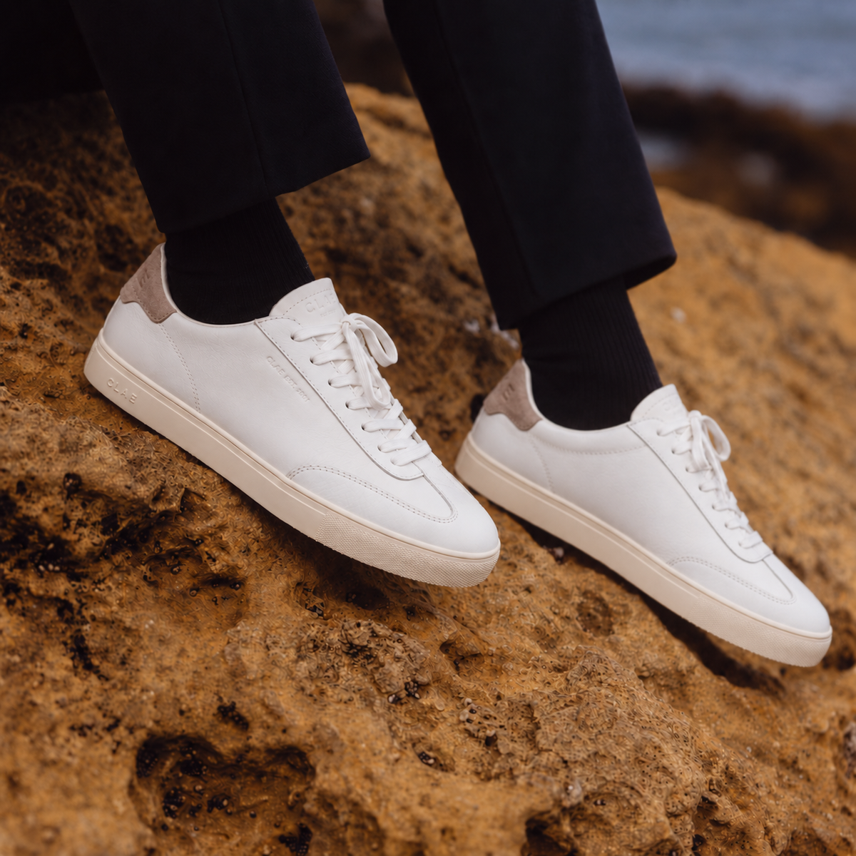 CLAE DEANE White Cobblestone leather sneakers worn on seaside rocks