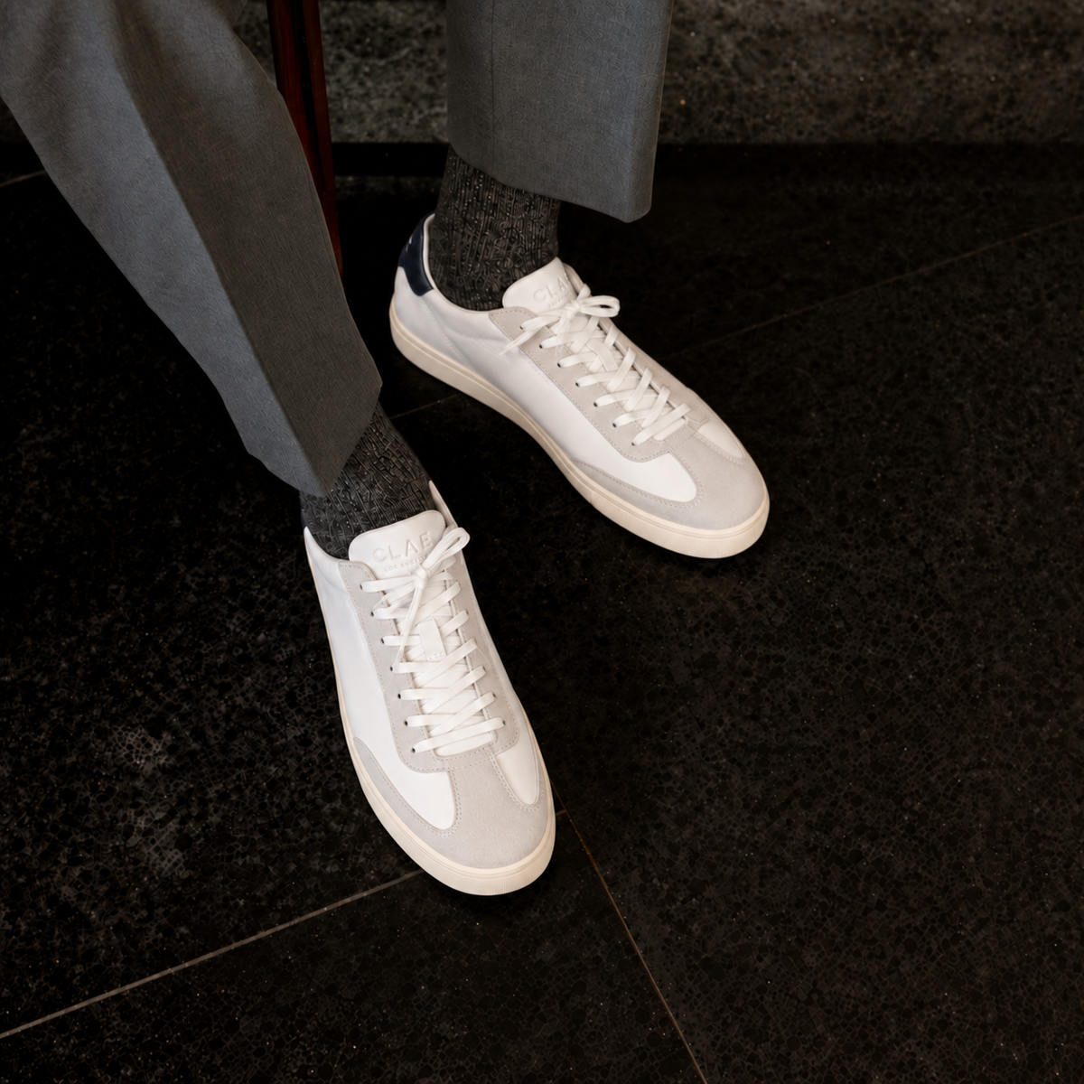 CLAE DEANE White Leather Navy – worn with grey trousers